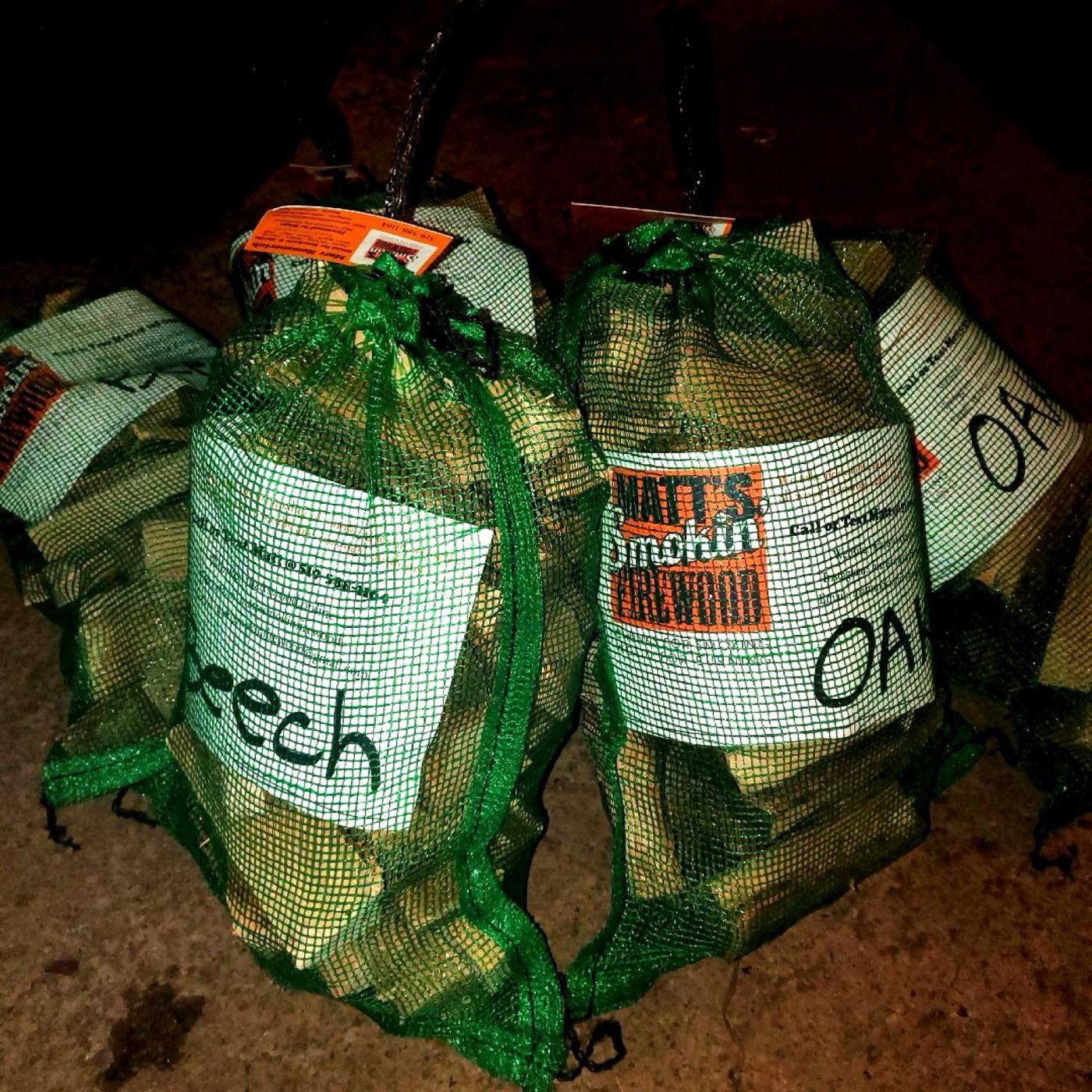 Mesh bags of beech and oak smoking wood labelled and stacked, ready for pickup