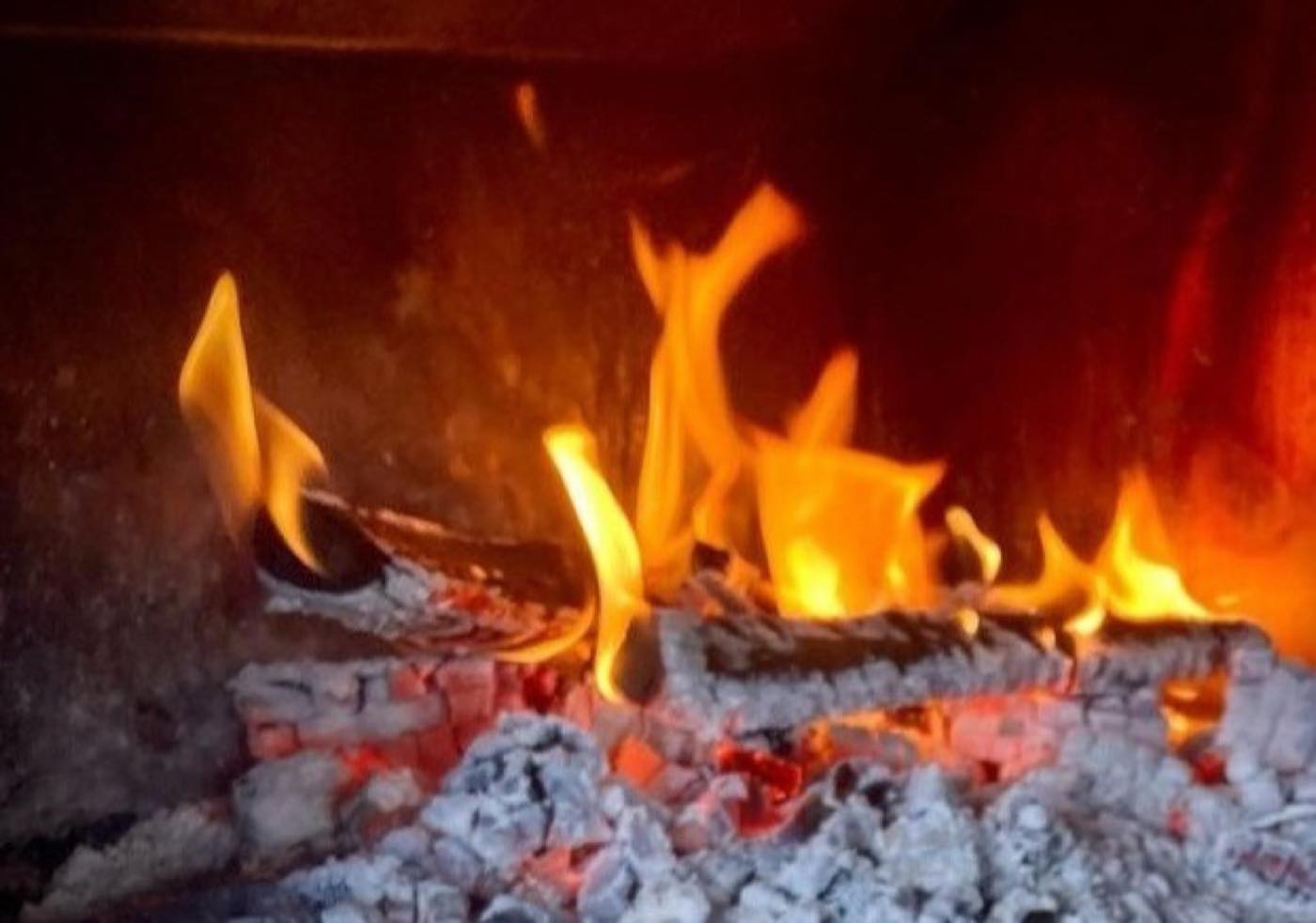 Flames rolling across the floor of a wood-fired oven